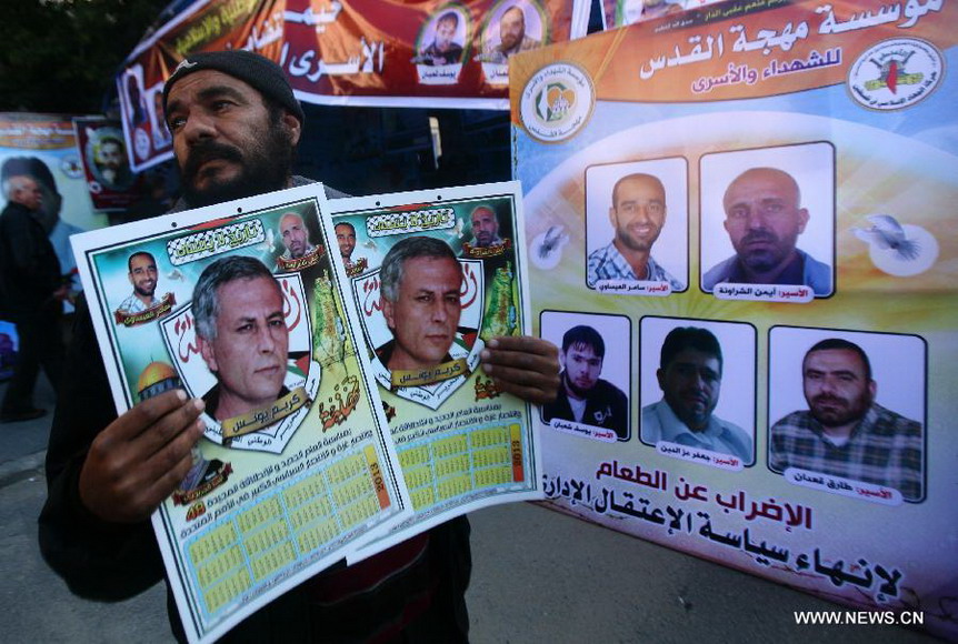 Palestinians attend a rally calling for the release of two Palestinian prisoners in Israeli jails, in the West Bank city of Nablus on Dec. 17, 2012. The two prisoners, Ayman Sharawneh and Samer Isawi, have been going on a hunger strike for over four months in Israeli jails against their administrative detention. (Xinhua/Nidal Eshtayeh)  