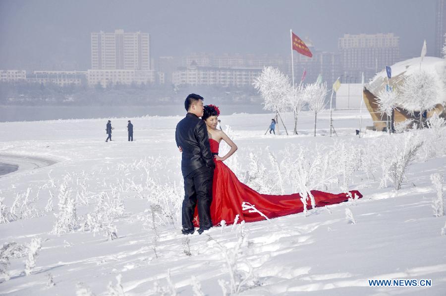 A newly-married couple pose for wedding photo among rime along Songhua River in Jilin City, northeast China's Jilin Province, Dec. 17, 2012. (Xinhua/Wang Mingming) 