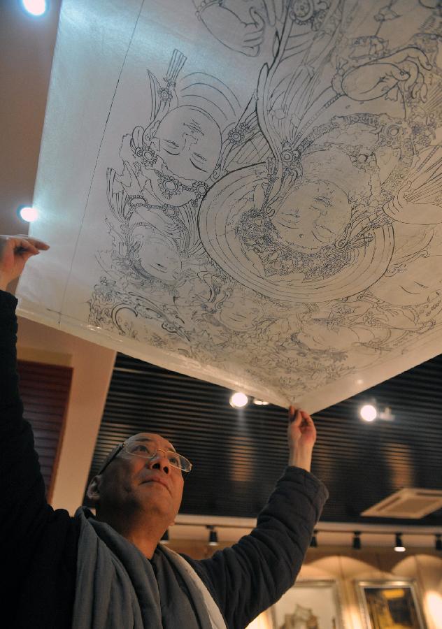 Teng Ting, the founder of a high temperature ceramic paints, holds his copy painting of the Grottoes in Jingdezhen, east China's Jiangxi Province, Dec. 4, 2012.(Xinhua/Zhang Wu) 