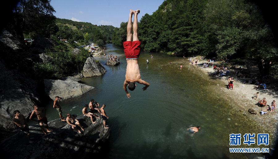 A man jumps into the Treska River in Skopje, capital of Macedonia on July 1, 2012. (Xinhua/AFP)