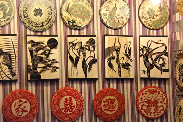 Wood carvings featuring ethnic cultural elements are displayed in a Lijiang shop. (Photo: CRIENGLISH.com/Zhang Linruo)