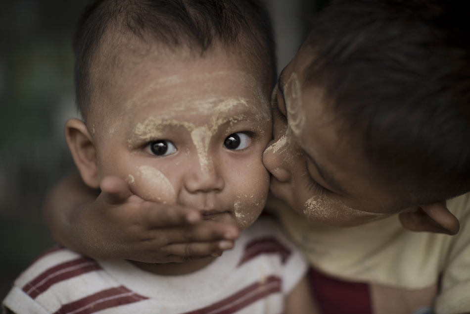 A boy kisses a baby on the face in Bago, Myanmar, Nov. 14, 2012.(Xinhua/AFP)