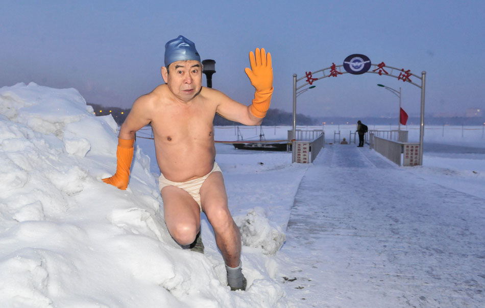 A man is doing warm-up exercise before jumping into the icy water in Changchun, capital city of northeast China’s Jilin province, Dec. 18, 2012(Xinhua/Wu Haofei)