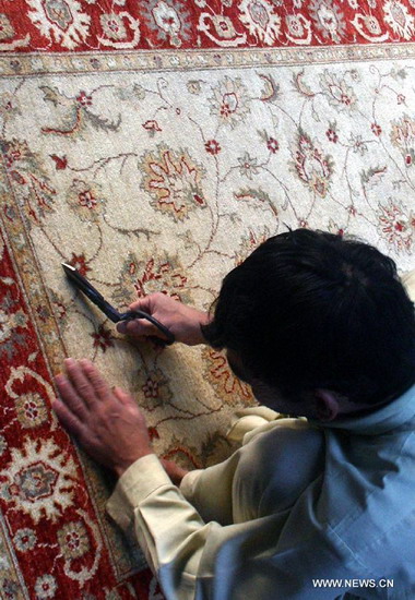 A Pakistani man works on a hand-made carpet at a local carpet factory in northwest Pakistan's Peshawar, Dec. 20, 2012. According to reports, Pakistan's carpet exports have witnessed a huge decline of more than 50 percent during the last five years. (Xinhua/Ahmad Sidique) 