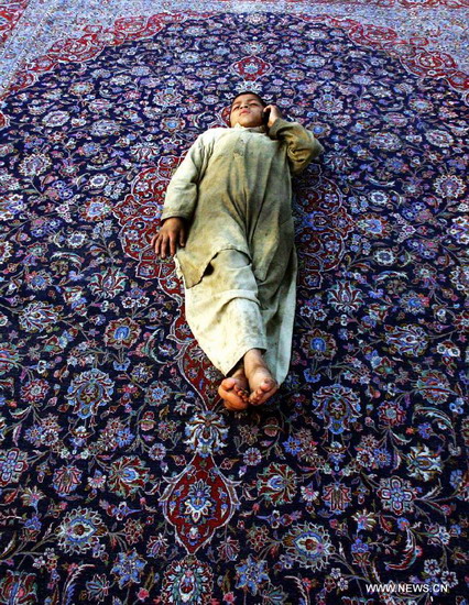 A Pakistani boy rests on a hand-made carpet at a local carpet factory in northwest Pakistan's Peshawar, Dec. 20, 2012. According to reports, Pakistan's carpet exports have witnessed a huge decline of more than 50 percent during the last five years. (Xinhua/Ahmad Sidique)