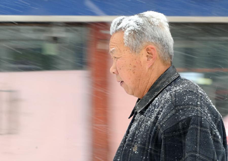 A pedestrian walks amid snow in Taiyuan, capital of north China's Shanxi Province, Dec. 20, 2012. Most parts of Shanxi witnessed a heavy snow on Thursday. (Xinhua/Yan Yan)