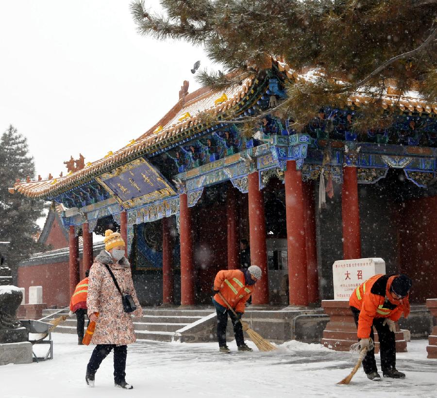 Sanitation workers clean the snow near a temple in Hohhot, capital of north China's Inner Mongolia Autonomous Region, Dec. 20, 2012. A heavy snow hit Inner Mongolia on Thursday, bringing a big temperature drop and winds to the region.(Xinhua/Liu Yide) 