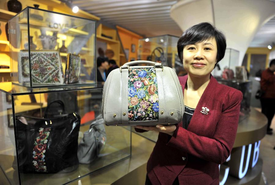 A staff member shows a embroidered leather bag during the 7th China (Beijing) International Cultural and Creative Industry Expo (ICCIE) in Beijing, capital of China, Dec, 20, 2012. The expo, which opened here on Thursday, attracted some 50 delegations from 6 international organizations and 15 countries and regions. (Xinhua/Li Wen) 