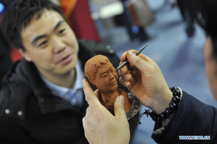 An artist makes a clay sculpture for a visitor during the 7th China (Beijing) International Cultural and Creative Industry Expo (ICCIE) in Beijing, capital of China, Dec, 20, 2012. The expo, which opened here on Thursday, attracted some 50 delegations from 6 international organizations and 15 countries and regions. (Xinhua/Lu Peng) 