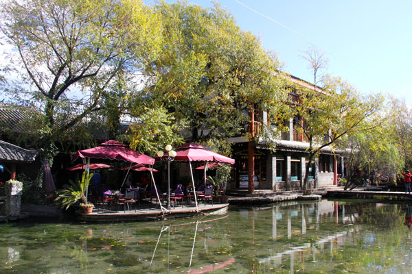 An outdoor coffeehouse near a body of still and clear water enhances the laid-back lifestyle of Shuhe Ancient Town. (CRI Photo)