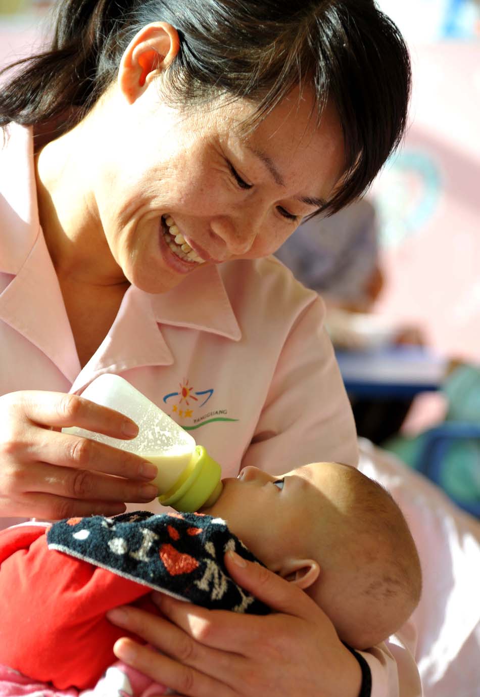 Yang Shouwei feeds an infant in Children's Welfare Institute in Weifang, Shandong on Dec.7 2012. (Xinhua/Xu Suhui)