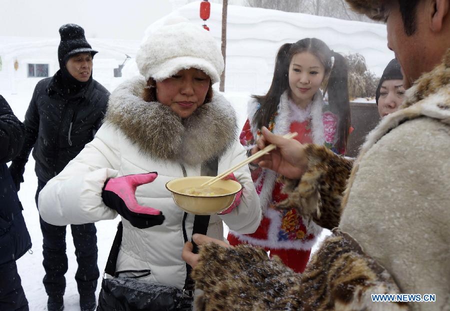 A working staff invites a tourist to taste the Chinese sauerkraut during the 25th Harbin Sun Island International Snow Sculpture Art Expo. in Harbin, capital of northeast China's Heilongjiang Province, Dec. 21, 2012. The expo kicked off on Friday. (Xinhua/Wang Feng) 