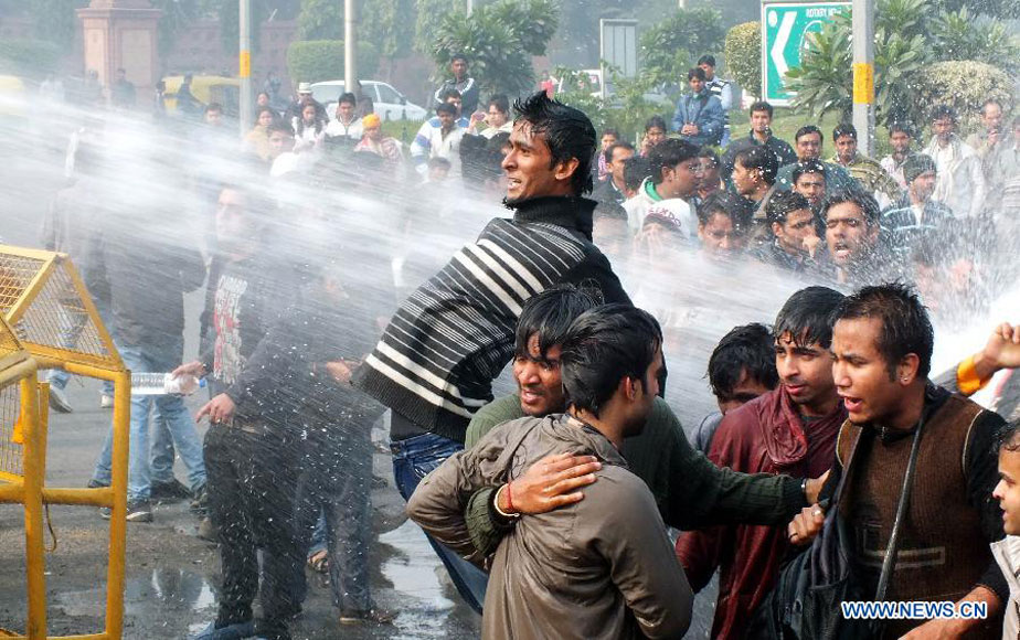 A protestor confronts water cannoned by police during a demonstration at the India Gate in New Delhi, India, on Dec. 23, 2012. Indian students Sunday continued their week-long protest against a horrifying gangrape of a young woman last Sunday and asked Congress President Sonia Ganghi to immediately intervene. (Xinhua/Partha Sarkar)   