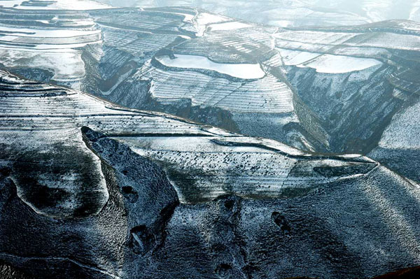 Northwest China's Gansu Province, spreading some 1600 kilometers across the Huangtu Plateau (The Loess Plateau), used to be an important passage along the Ancient Tea Horse Road. Today, its rigid yet majestic landscape still attracts numerous visitors who come in search of its historical relics and natural vistas. These photos taken recently by a local photographer show the Gobi Desert and sand dunes on the plateau covered by a thin layer of snow. (CRIENGLISH.com/Sang Zhiqing)