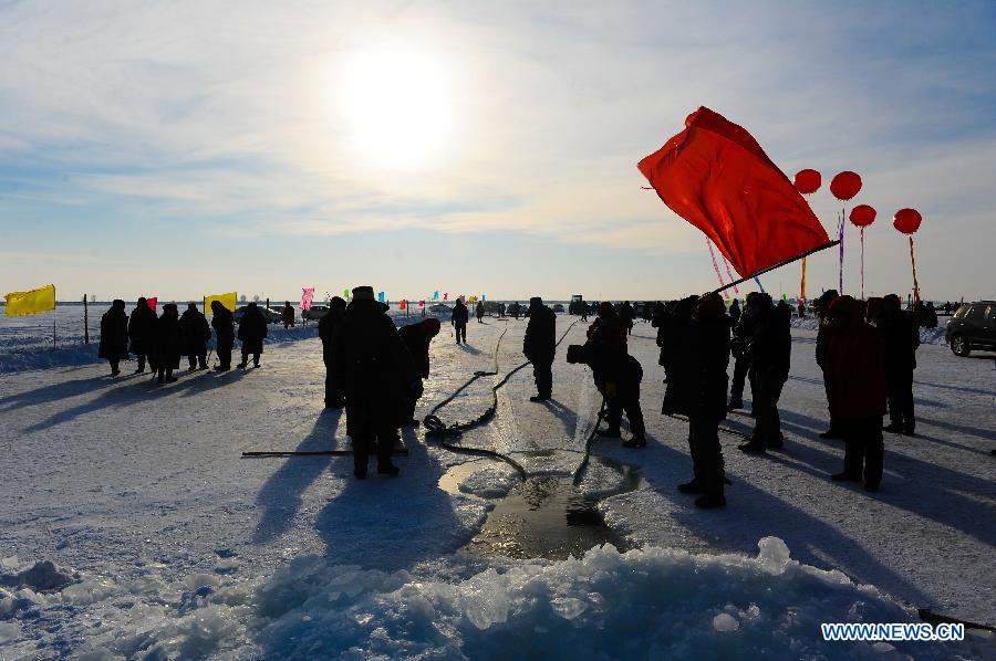 Fishmen catch fish with net during an ice fishing festival in Zhenlai County, northeast China's Jilin Province, Dec. 24, 2012. (Xinhua/Xu Chang)