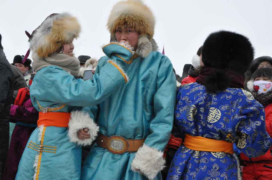 Photo taken on Dec. 24 shows audience wearing national costumes at the opening ceremony of 2012 Inner Mongolia Winter Ice and Snow Nadam Fair as well as the Fire Sacrifice Festival of Chenbaerhu Grassland in Hulun Buir, north China's Inner Mongolia Autonomous Region. (People's Daily Online/Zeng Shurou)