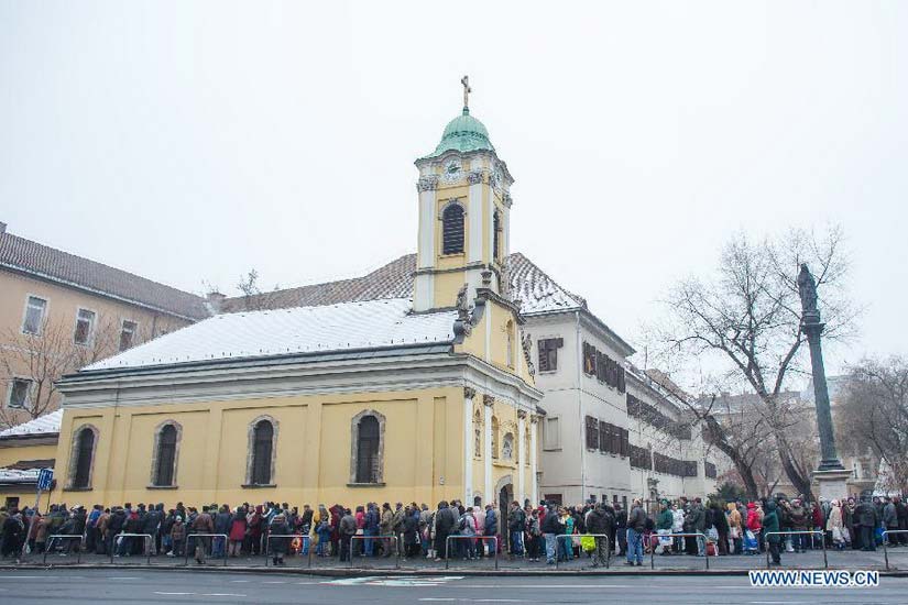People queue for free food distributed by Krishna charity activists in Budapest, Hungary, on Dec. 25, 2012. (Xinhua/Attila Volgyi) 