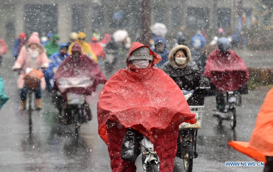 Citizens ride in snow on a street in Yangzhou, east China's Jiangsu Province, Dec. 26, 2012. Many parts of Jiangsu saw a snowfall on Wednesday. (Xinhua/Meng Delong) 
