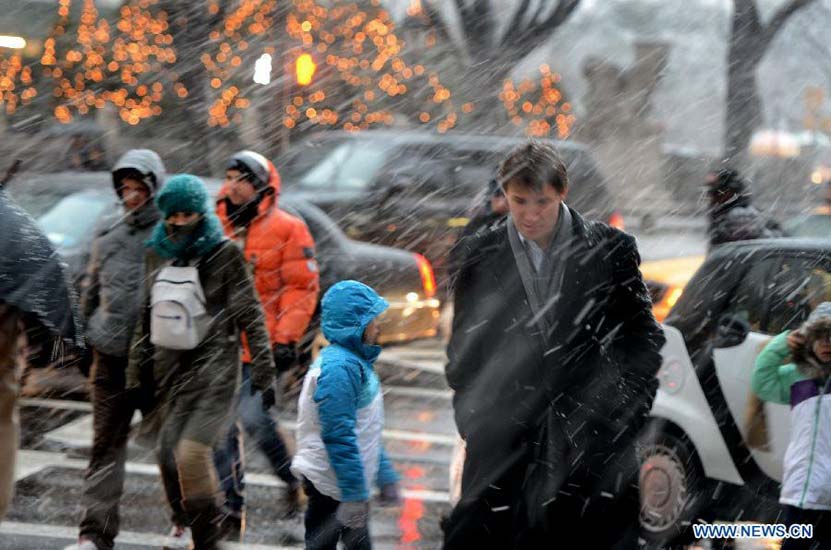 People walk in a winter storm as snow falls in Manhattan, New York City, on Dec. 26, 2012. The strong storm system that hit the central and southern U.S. on Christmas Day moved to the eastern U.S. on Wednesday, causing flight delays and dangerous road conditions in the Northeast. (Xinhua/Wang Lei) 