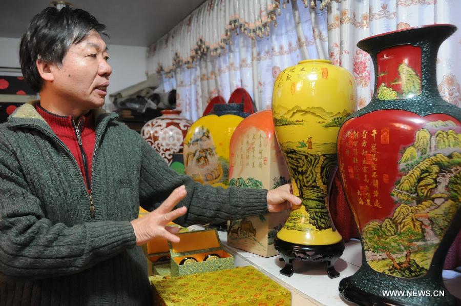 Craftsman Lin Youxin introduces his Fuzhou bodiless lacquerware works in Fuzhou, capital of southeast China's Fujian Province, Dec. 26, 2012. (Xinhua/Lin Shanchuan) 