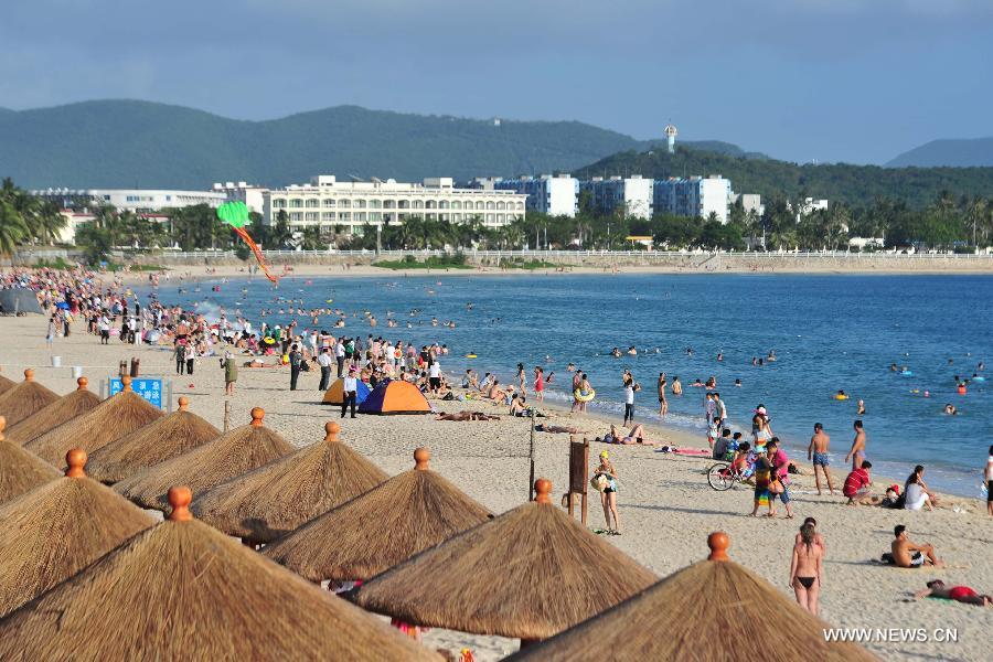 Tourists enjoy themselves at a beach in Sanya, a popular winter toursim destination in south China's Hainan Province, Dec. 27, 2012. (Xinhua/Hou Jiansen)