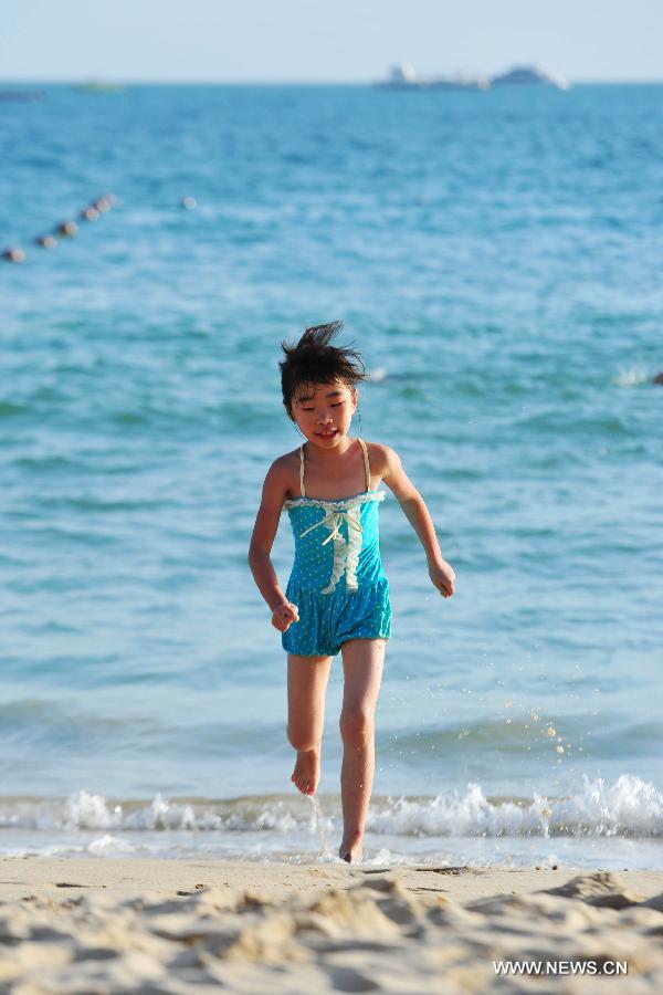 A girl plays at a beach in Sanya, a popular winter toursim destination in south China's Hainan Province, Dec. 27, 2012. (Xinhua/Hou Jiansen)