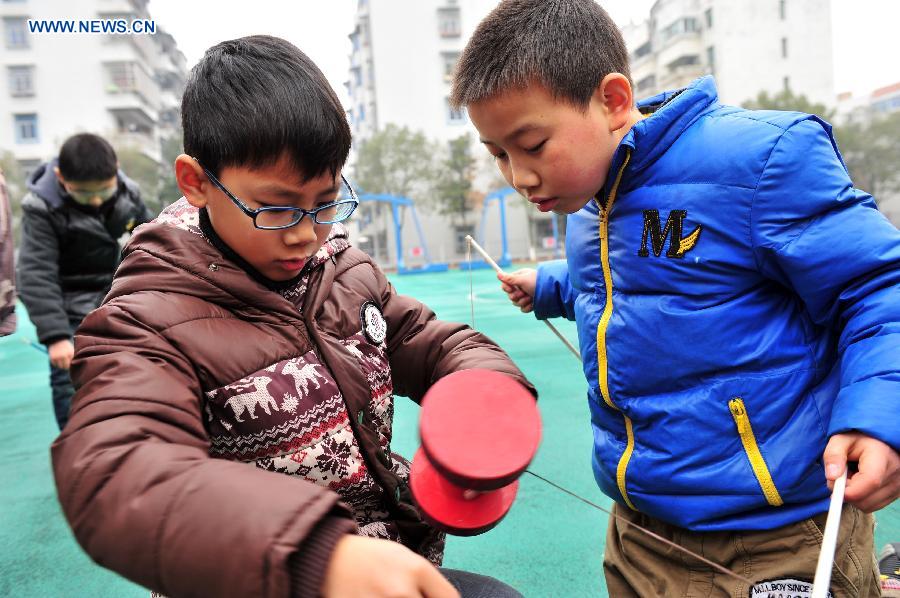 Pupils play traditional Kongzhu, also known as diabolo, at the playground of the Zigui experimental primary school in Zigui County, central China's Hubei Province, Dec. 27, 2012. Kongzhu literarily means empty bamboo, and is one of the major Chinese traditional toys along with shuttlecocks and kites. It is a popular activity among people of various ages. (Xinhua/Wang Huifu)