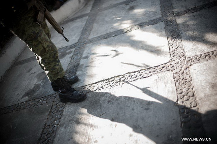 A Mexican Army soldier stands guard at a site where weapons are exchanged for groceries and cash by residents as part of "For your family, voluntary disarmament" program held at Iztapalapa Deputation, in Mexico City, capital of Mexico, on Dec. 27, 2012. (Xinhua/Pedro Mera) 