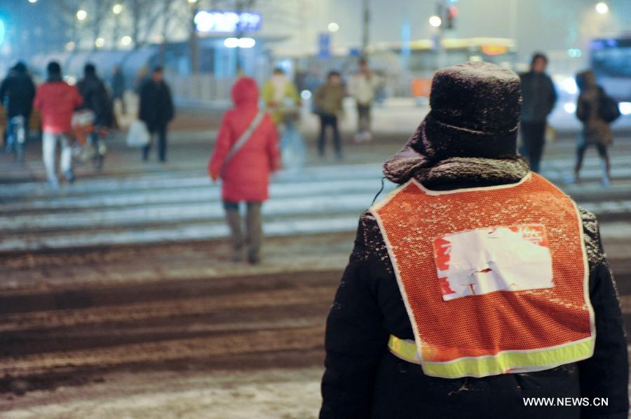 A traffic warden directs traffic in Beijing, capital of China, Dec. 28, 2012. Beijing has witnessed the 7th snowfall in this winter on Friday. (Xinhua/Sun Ruibo)