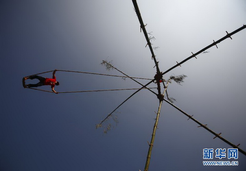 A youth plays on a swing during the first day of Dashain Festival in Kathmandu, Nepal on Oct. 16, 2012. It is the biggest religious festival, 10-15days National Holiday. People sacrifice animals and worship gods to pray for a long and happy life. (Xinhua/Reuters Photo) 