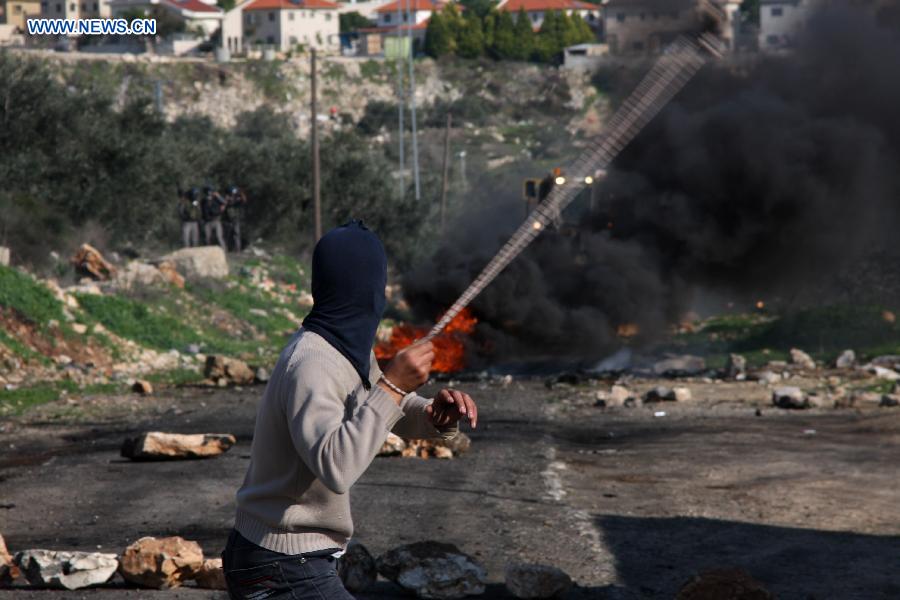 A Palestinian protester throws stones at Israeli soldiers during a protest against the expanding of Jewish settlement in Kufr Qadoom village near the West Bank city of Nablus, on Dec. 28, 2012. (Xinhua/Nidal Eshtayeh) 