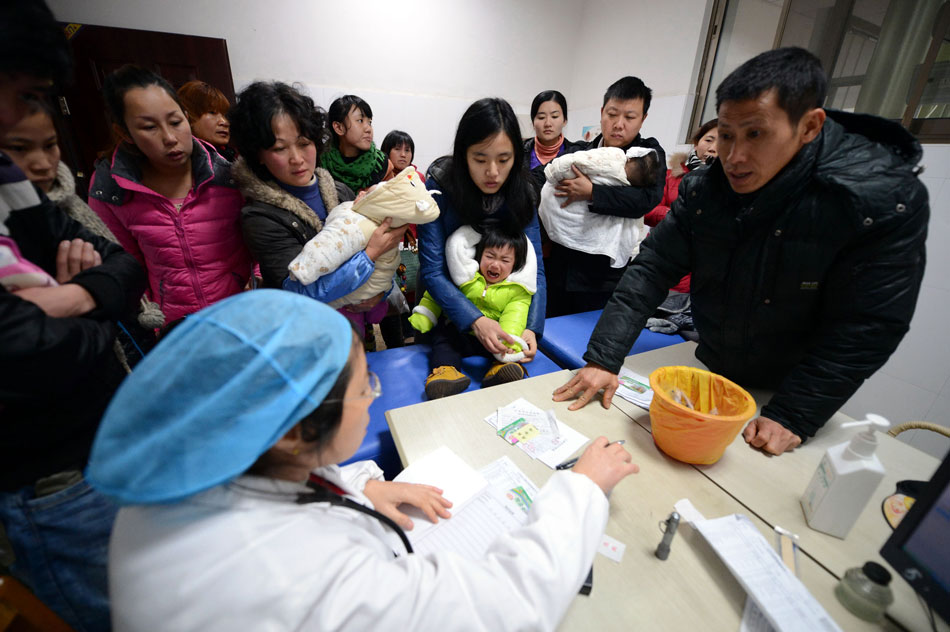 Parents take sick children to see doctors in the Children’s Hospital of Jiangxi on Dec. 26, 2012. Due to the recent cold weather, the number of sick children surged in Jiangxi. (Xinhua/Zhou Mi)