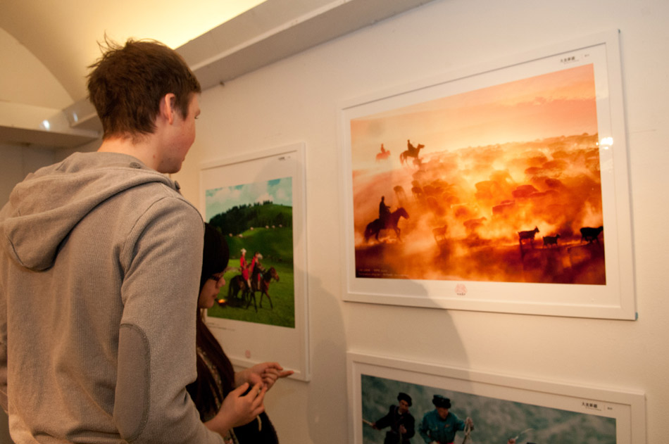 Visitors appreciate the photography exhibition “Great beauty of Xinjiang” in the King’s Garden in Stockholm, Sweden, Dec. 22, 2012.(Xinhua/Liu Yinan)