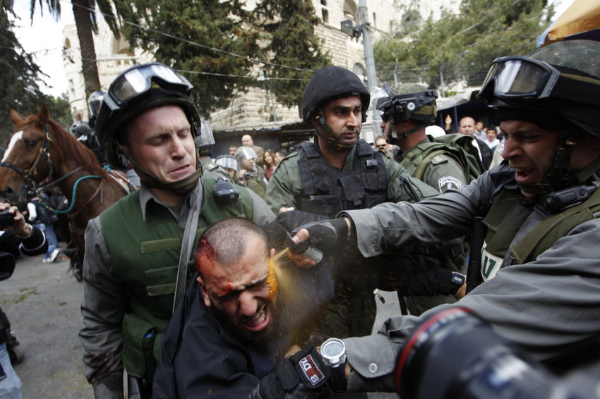 Israeli border police officers fire tear-gas while they detain an injured Palestinian demonstrator in a conflict on Land Day on March 30, 2012.  (Reuters/AmmarAwad)