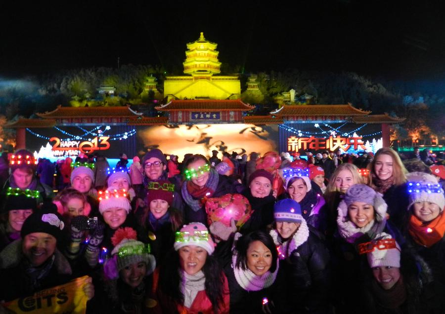 Tourists from home and abroad pose for a photo at the Summer Palace in Beijing, capital of China, Dec. 31, 2012. Thousands of tourists from home and abroad witnessed the New Year countdown here on Monday night to welcome the new year. (Xinhua/Wang Zhen)  