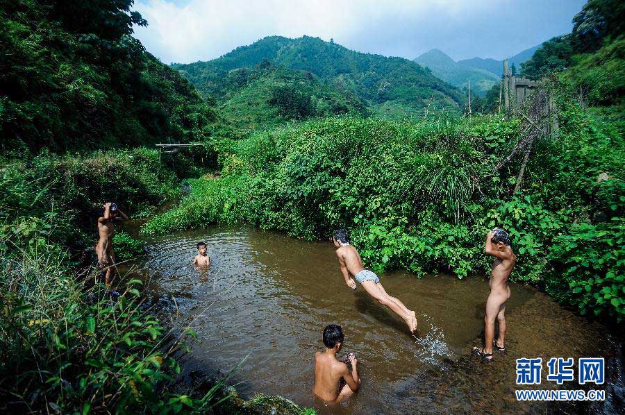 Growth is achieved by fun time with friends: Children are playing in a pond in a village of Hunan province, Aug. 15, 2012. (Xinhua/Bai Yu)