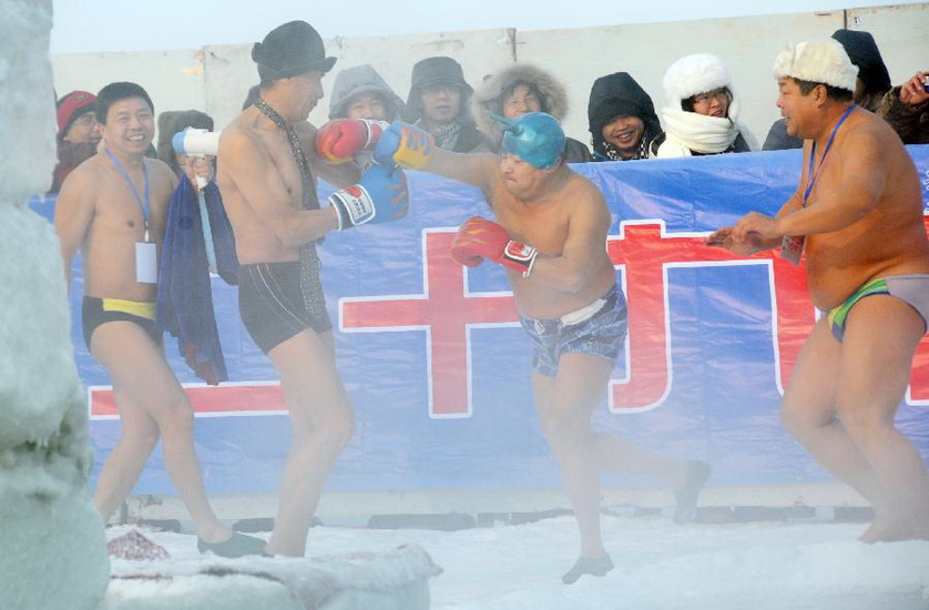 Winter swimmers perform on-ice boxing in Harbin, capital of northeast China's Heilongjiang Province, Jan. 1, 2013. Over 2,000 tourists from home and abroad watched the winter swimming performance here on Tuesday, the New Year's Day. (Xinhua/Liu Yang) 