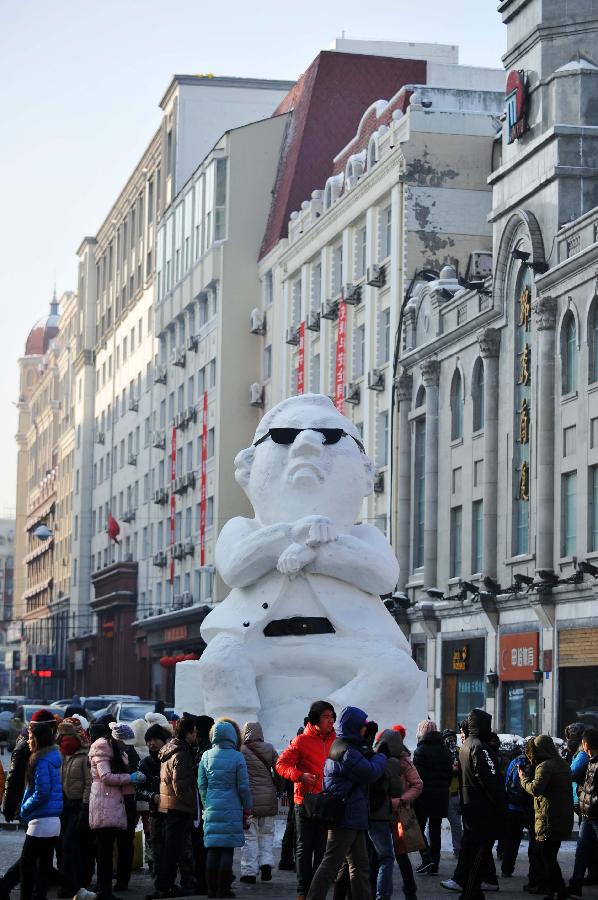 Tourists gather in front of a snow sculpture of South Korean rapper Psy in Harbin, capital of northeast China's Heilongjiang Province, Jan. 2, 2013. Psy's music video of "Gangnam Style," featuring the horse-riding dance, became a global sensation this year. (Xinhua/Wang Jianwei)