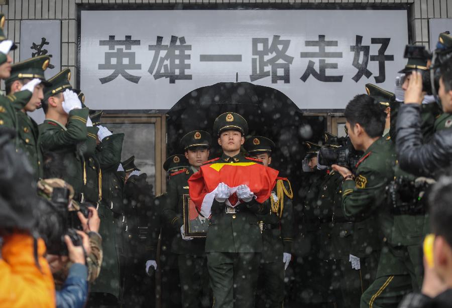 A soldier holds bone ashes of a deceased firefighter who lost life in a rescue operation on Jan. 1 at the Hangzhou Yusei Machinery Co., Ltd during memorial meeting in Hangzhou, capital of east China's Zhejiang Province, Jan. 4, 2013. (Xinhua/Han Chuanhao) 