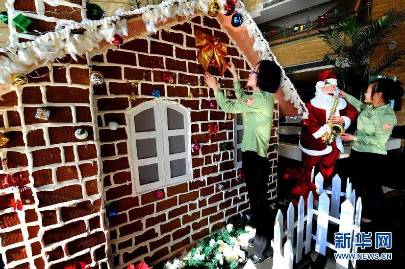 Edible Christmas Room： People are decorating a Christmas room in a hotel in Taicang, Jiangsu province on Dec. 19, 2012. The delicate room is made of coffee biscuits, honey and sugar. (Xinhua/Yao Jianping)
