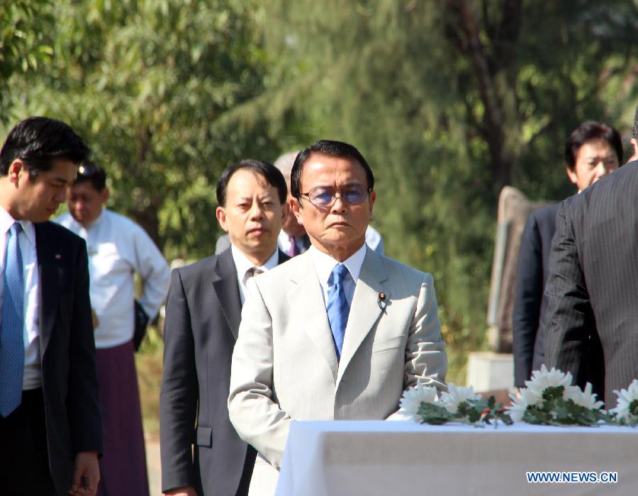 Japanese Deputy Prime Minister and Finance Minister Taro Aso (C, in White) visits the War Cemetery in Yangon, Myanmar, Jan. 4, 2013. Japanese Deputy Prime Minister and Finance Minister Taro Aso's visit to the War Cemetery in Yangon's suburban area Friday has raised protests by some war veterans who experienced the Japanese aggressive war in Myanmar. (Xinhua/U Aung) 