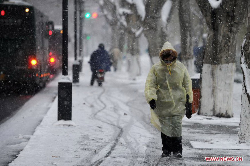 A pedestrian walks against the snow along a street in Hangzhou, capital of east China's Zhejiang Province, Jan. 4, 2013. Many areas in Zhejiang received snowfalls on Friday. The local meteorological authority issued an orange alert for icy roads on Friday morning, warning the possible disruption which the continued snow might cause to traffic, power supply and agriculture. (Xinhua/Ju Huanzong)