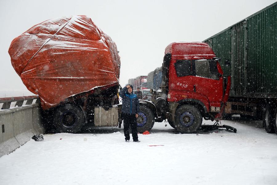 A truck veers off the road on the snow-covered Nanchang-Zhangshu section of the Shanghai-Kunming highway in east China's Jiangxi Province, Jan. 4, 2013. Vehicles were blocked in a traffic jam on the highway for a couple of hours due to a heavy snowfall in Jiangxi on Friday. (Xinhua/Zhou Ke)