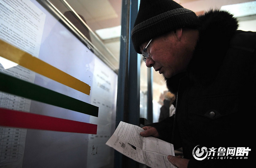 Zhang Shangxue looks at information in the exam room in Shandong University of Traditional Chinese Medicine on Jan. 4, 2012. (Photo/yx.iqilu.com)