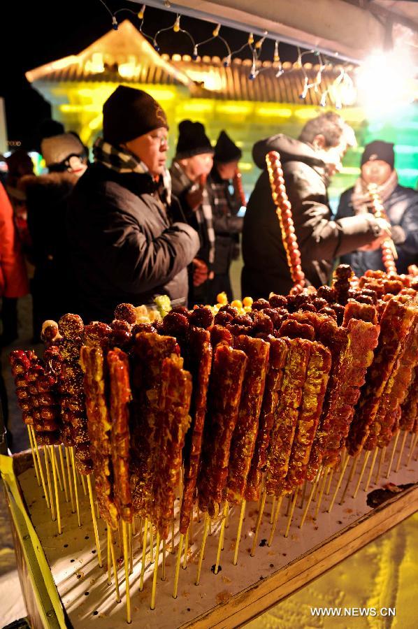 Visitors buy snacks in the Ice and Snow World during the 29th Harbin International Ice and Snow Festival in Harbin, capital of northeast China's Heilongjiang Province, Jan. 5, 2013. The festival kicked off on Saturday. (Xinhua/Wang Song)