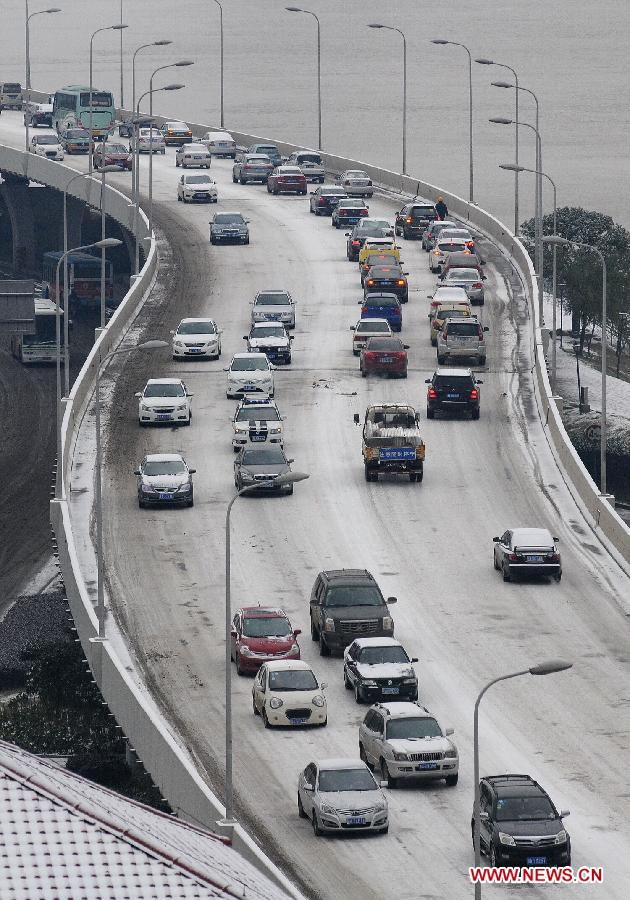 Vehicles run on a snow-affected bridge in Changsha, central China's Hunan Province, Jan. 4, 2013. Changsha witnessed this winter's heaviest snowfall on Friday. The snow has caused disruption in the city's urban traffic. (Xinhua/Long Hongtao)