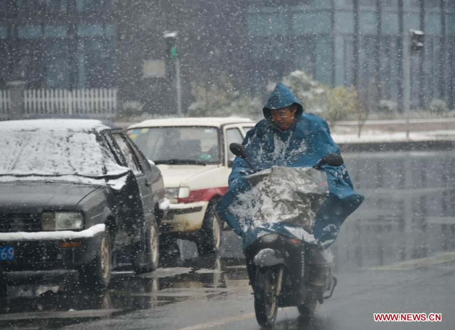 A man rides in snow on a street in Ji'an County, east China's Zhejiang Province, Jan. 4, 2013. Zhejiang Weather Bureau on Friday issued the first orange alert for road icing after the heavy snow and freezing weather since Thursday. (Xinhua/Xu Yu) 