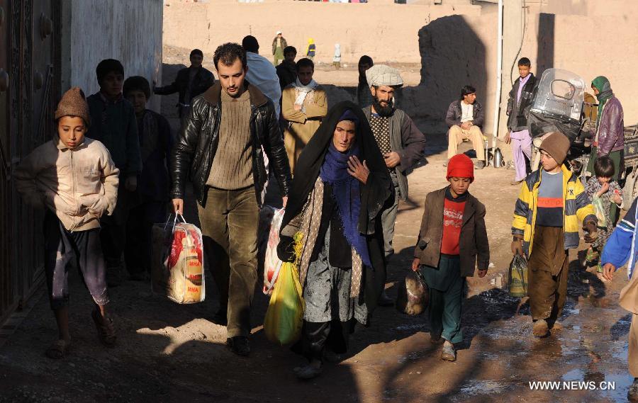 Afghan poor people carry winter relief assistance donated by rich people in Herat province of western Afghanistan on Jan. 5, 2013. Hundreds of poor families received winter relief assistance on Saturday. (Xinhua/Sardar) 