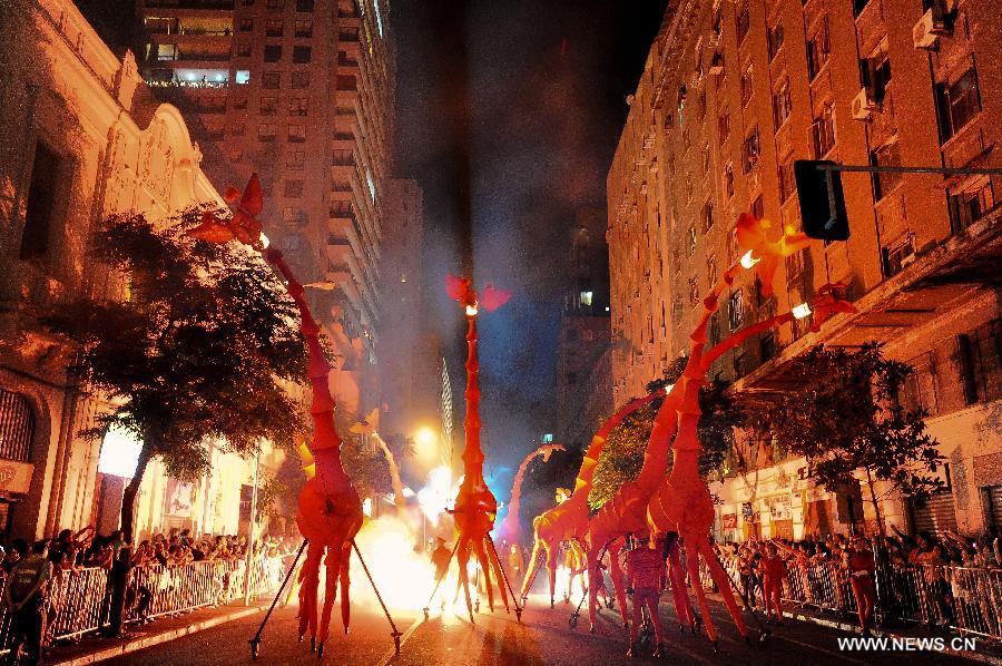 Figures of giraffes walk along a street during the presentation of street performance "The Giraffes" of the French company Off in the celebrations of the International Festival of theater "Santiago a Mil", in the city of Santiago, capital of Chile, on Jan. 5, 2013. The festival will last until Jan. 20 and feature 71 Chilean and International companies. (Xinhua/Jorge Villegas) 