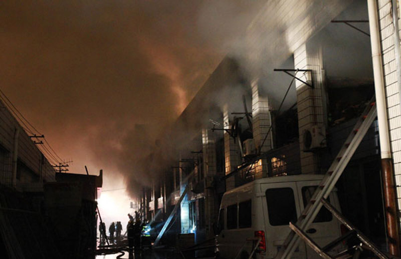 Smoke is seen billowing at a farm produce wholesale market in Shanghai as firefighters try to put out fire on Jan 6, 2013. (Photo/Xinhua)